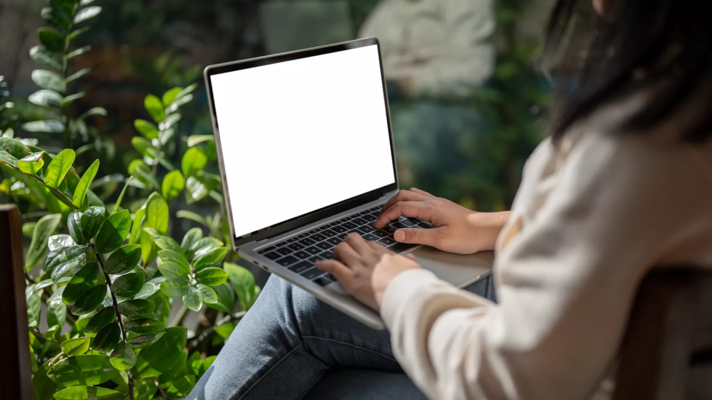 Laptop and green plants representing sustainable technology lifecycle planning
