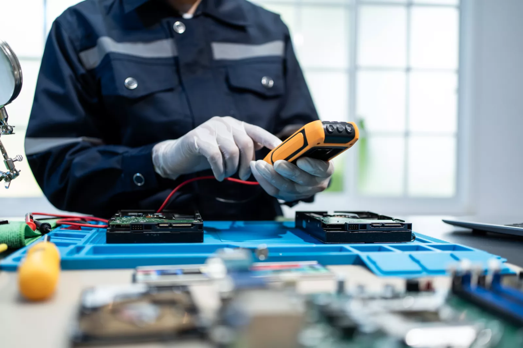 Technician in gloves tests computer hard drives