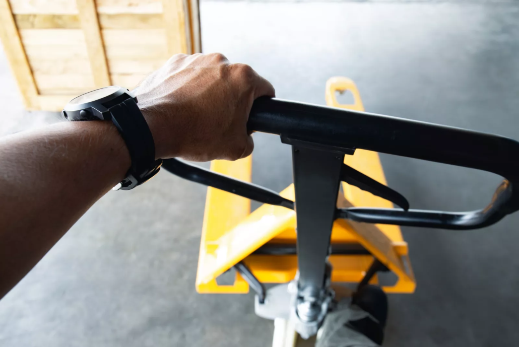 Worker using material handling equipment to move a heavy load safely